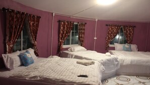 A room with three beds, purple walls, and patterned curtains. - Demy Home (Suan Phueng)