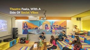 A cozy living area with a large screen, seating, and a colorful mural. - goSTOPS Delhi (New Delhi)