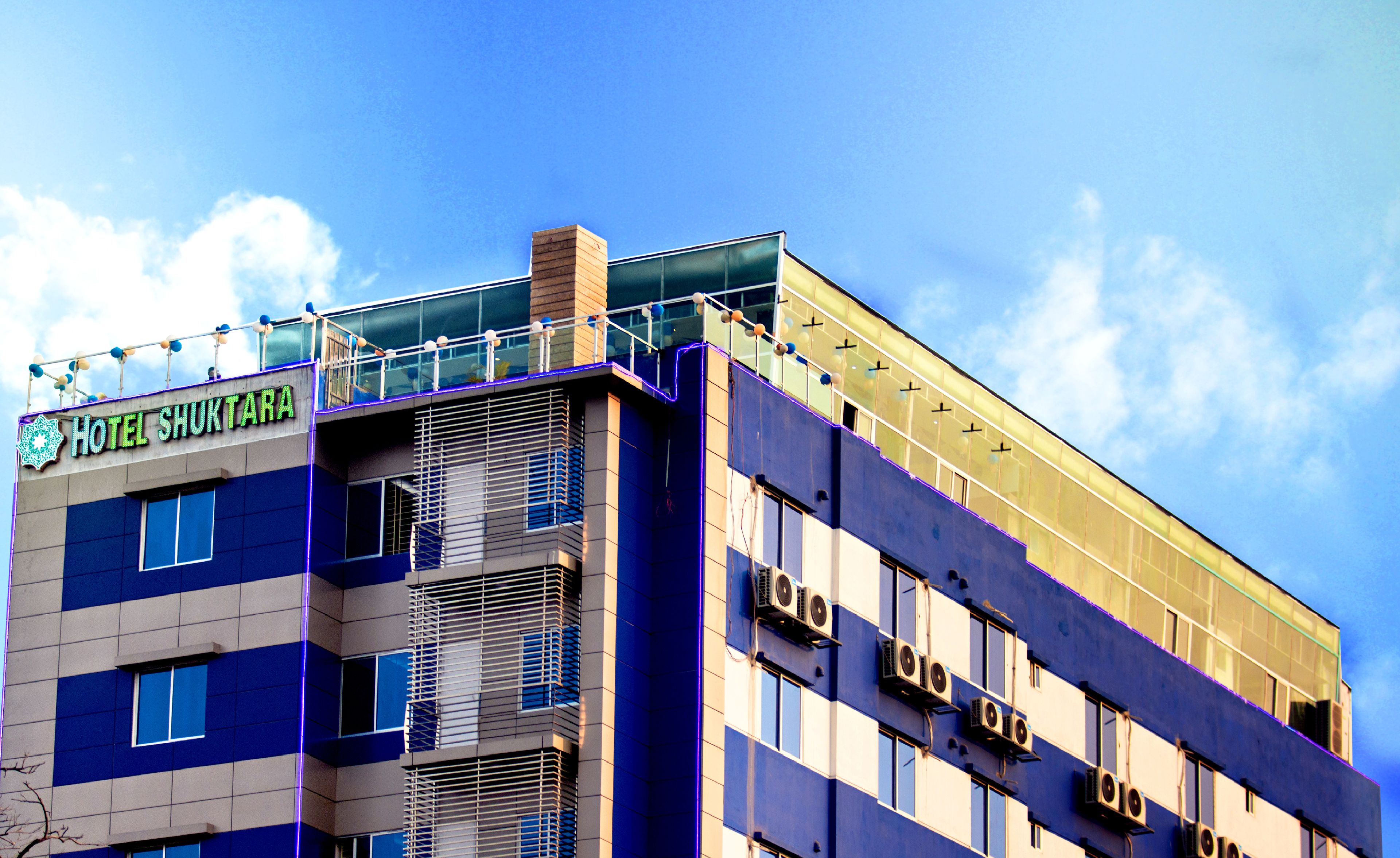 Et hotel med moderne design, med et tydeligt skilt for Hotel Shukhtar.
