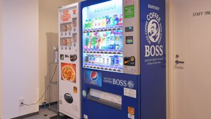 A vending machine with various beverages and snacks, including a Pepsi display, in a room with a door labeled "STAFF ONLY". - Nikko Station Hotel II bankan (Nikko)
