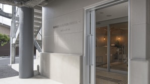 The exterior of Nikko Station Hotel II with a modern facade, a visible entrance, and a staircase leading to an upper level. - Nikko Station Hotel II bankan (Nikko)