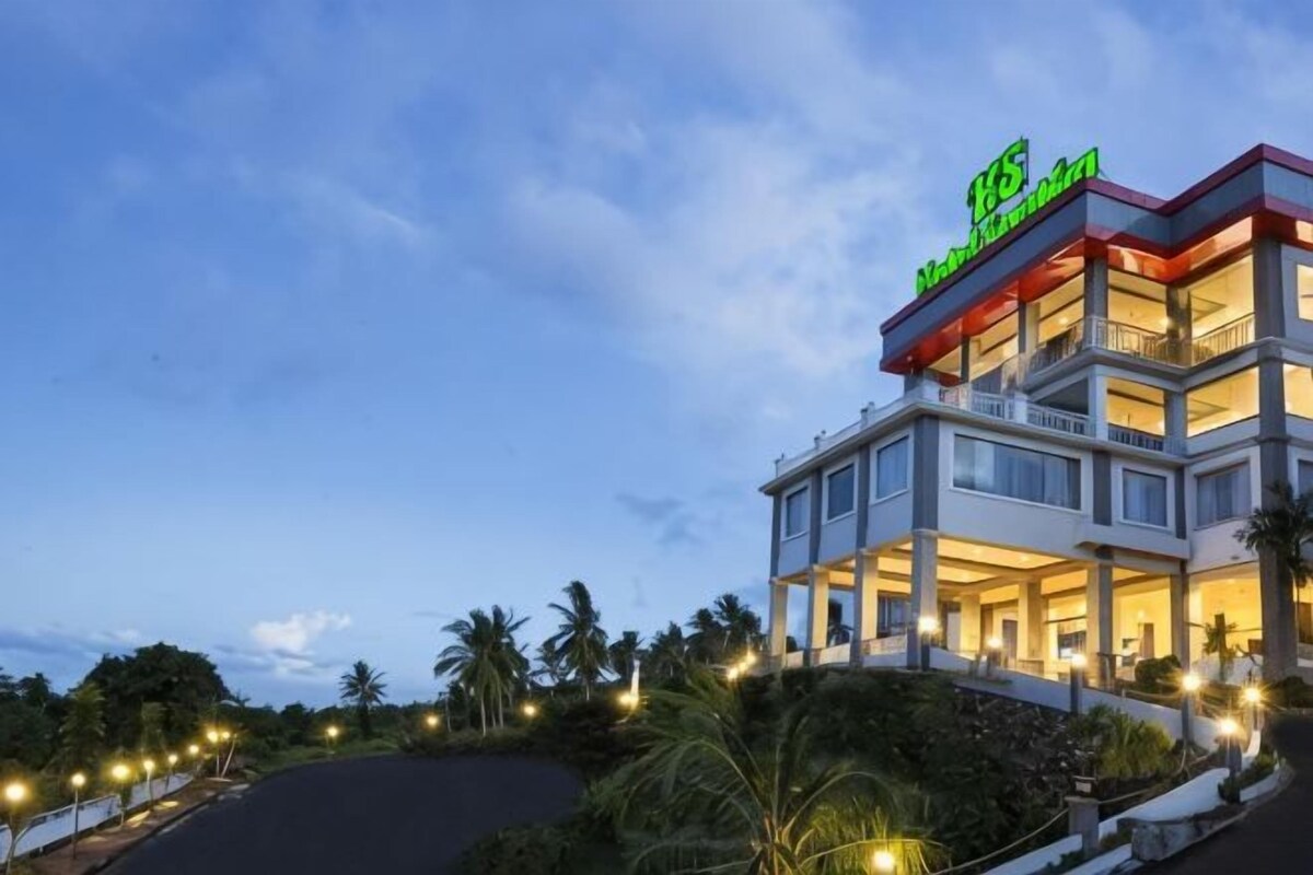 A multi-story hotel with a prominent sign, a covered outdoor area, and a landscaped garden.