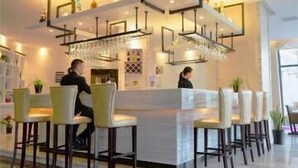 A modern bar area with high bar stools, a counter, and hanging light fixtures. - Metropolo Jinshanzui Village Hotel (Shanghai)