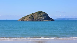 A small island with a rocky terrain and sparse vegetation, surrounded by calm blue waters. - Discovery Parks - Coolwaters Yeppoon (Kinka Beach)