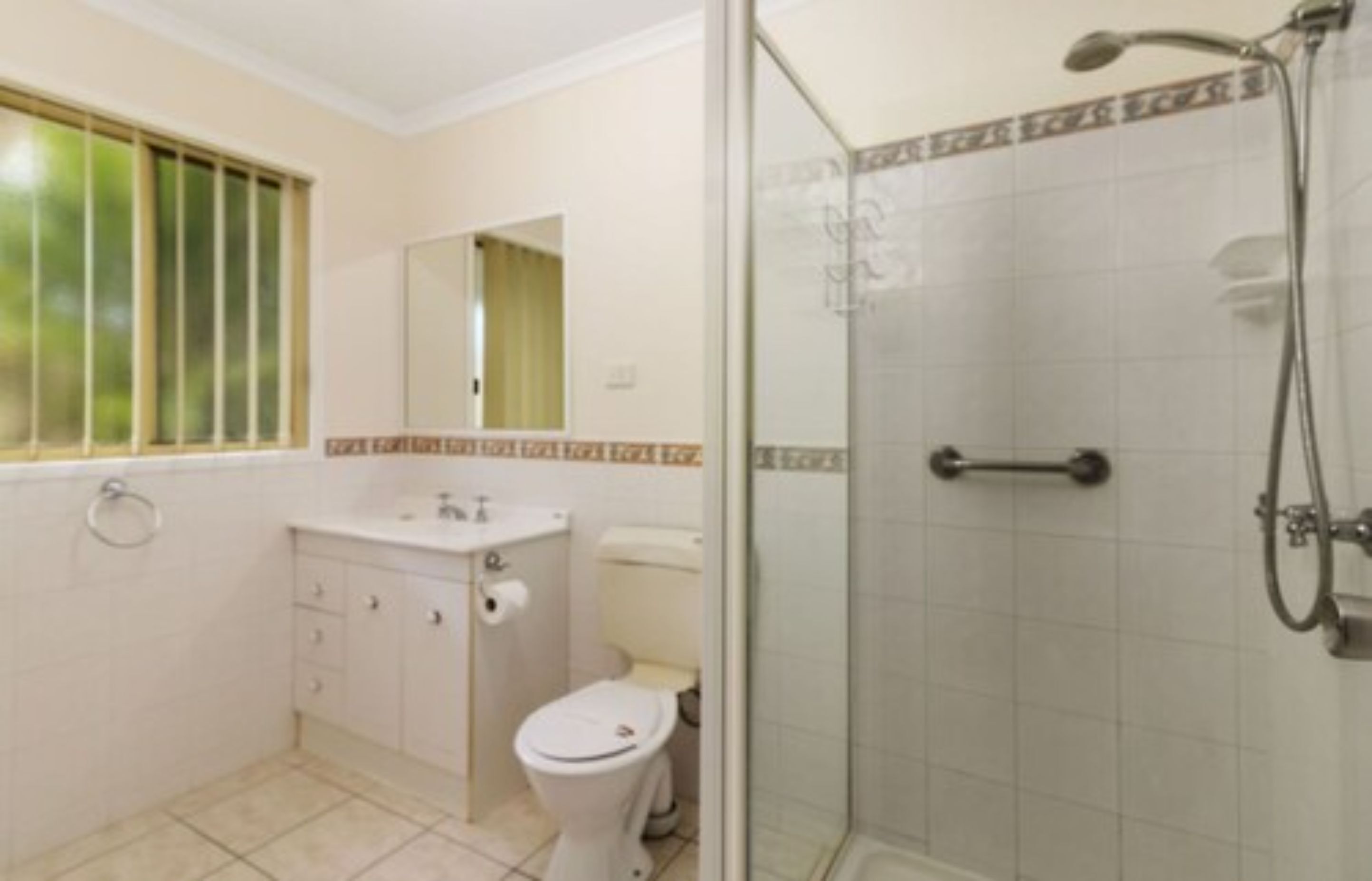 Egy fürdőszoba, amelyben WC, mosdókagyló és zuhanyzó található.