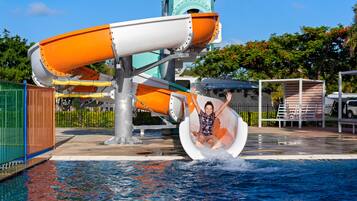 A water slide at a water park with a person sliding down.