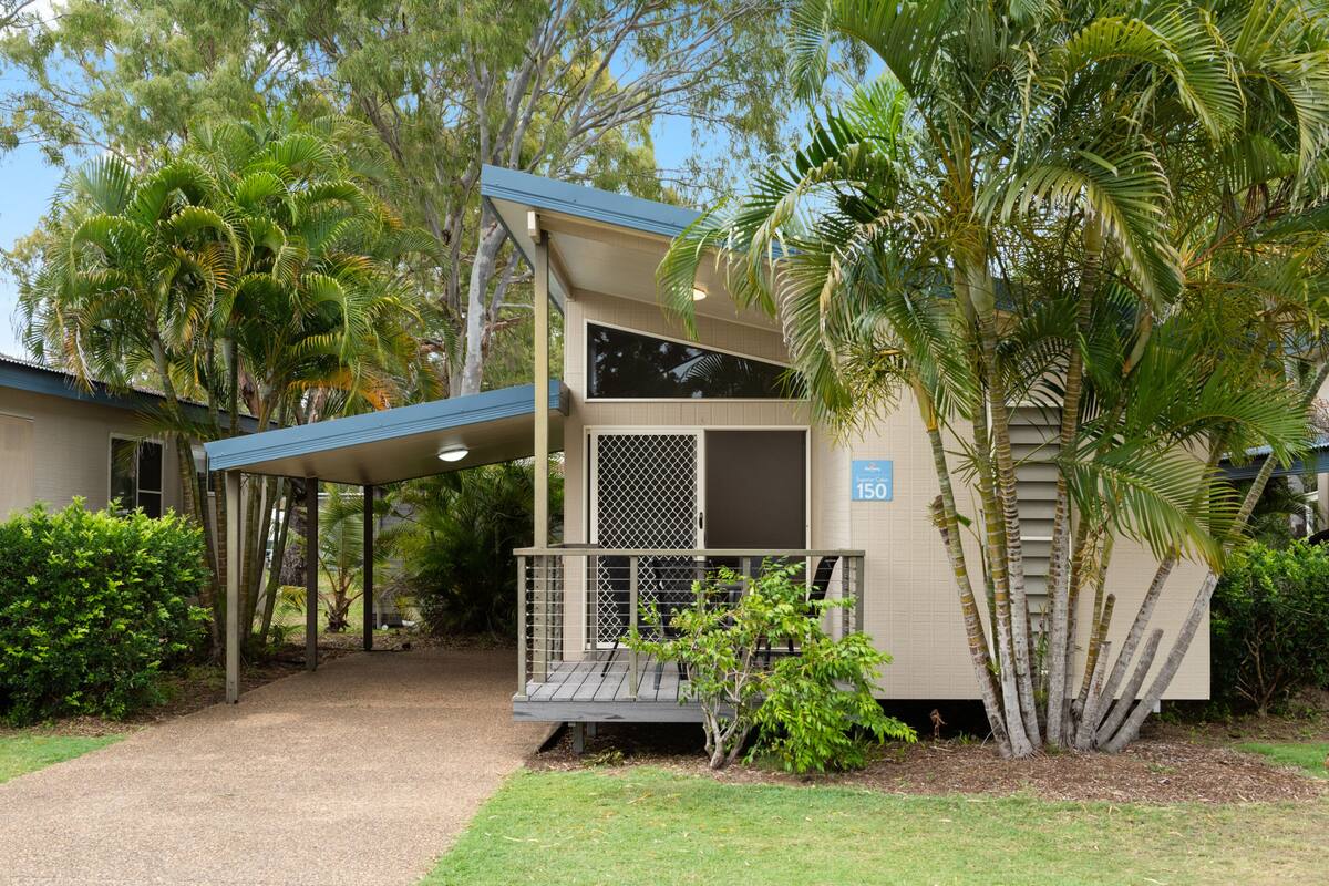A two-story building with a covered porch and a small garden area.