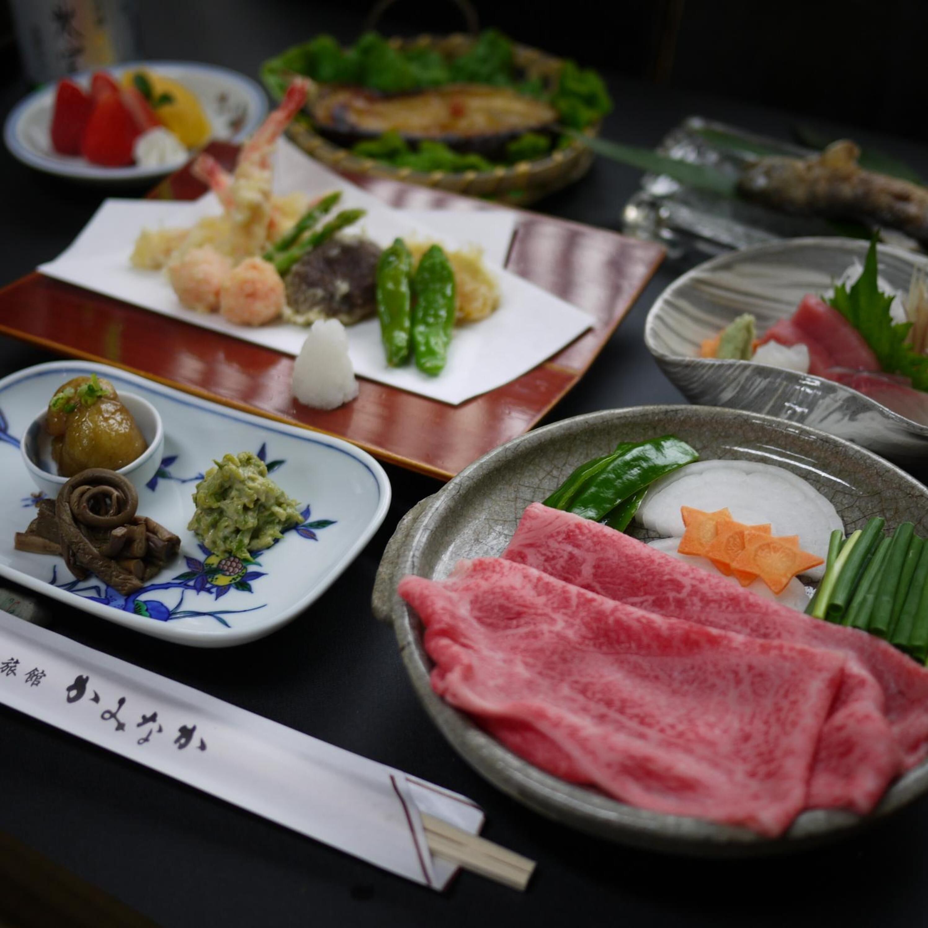 A variety of Japanese dishes on a table, including sushi, sashimi, and pickled vegetables.
