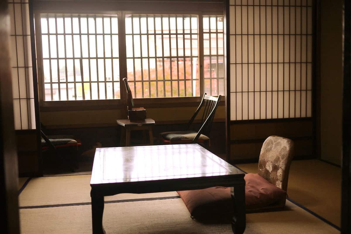 Een traditionele Japanse kamer met tatami vloeren, een lage tafel en twee stoelen.
