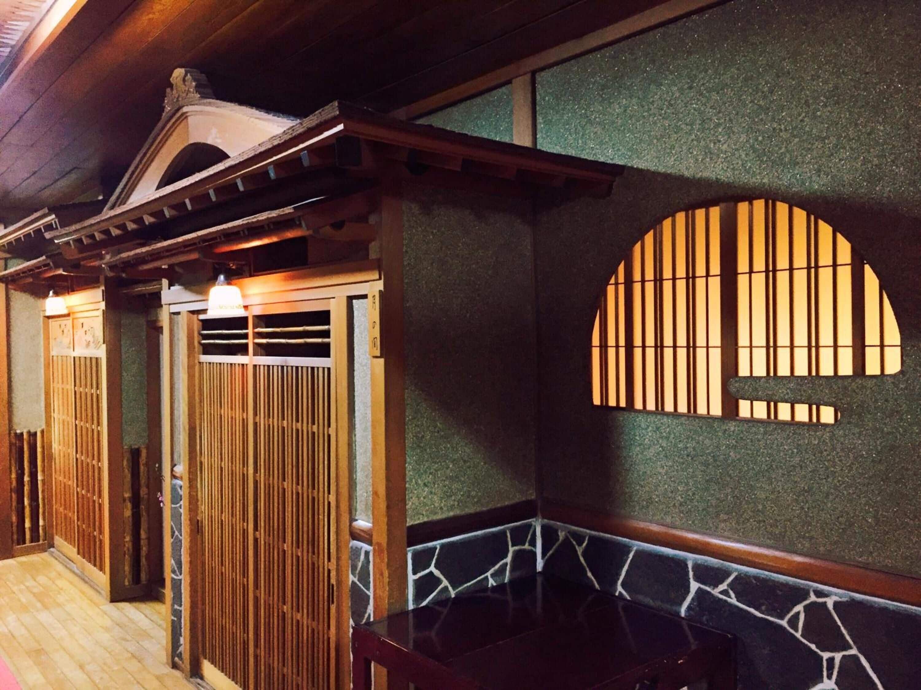 Una habitación japonesa tradicional con suelo de tatami, una mesa de madera baja y paneles shoji.