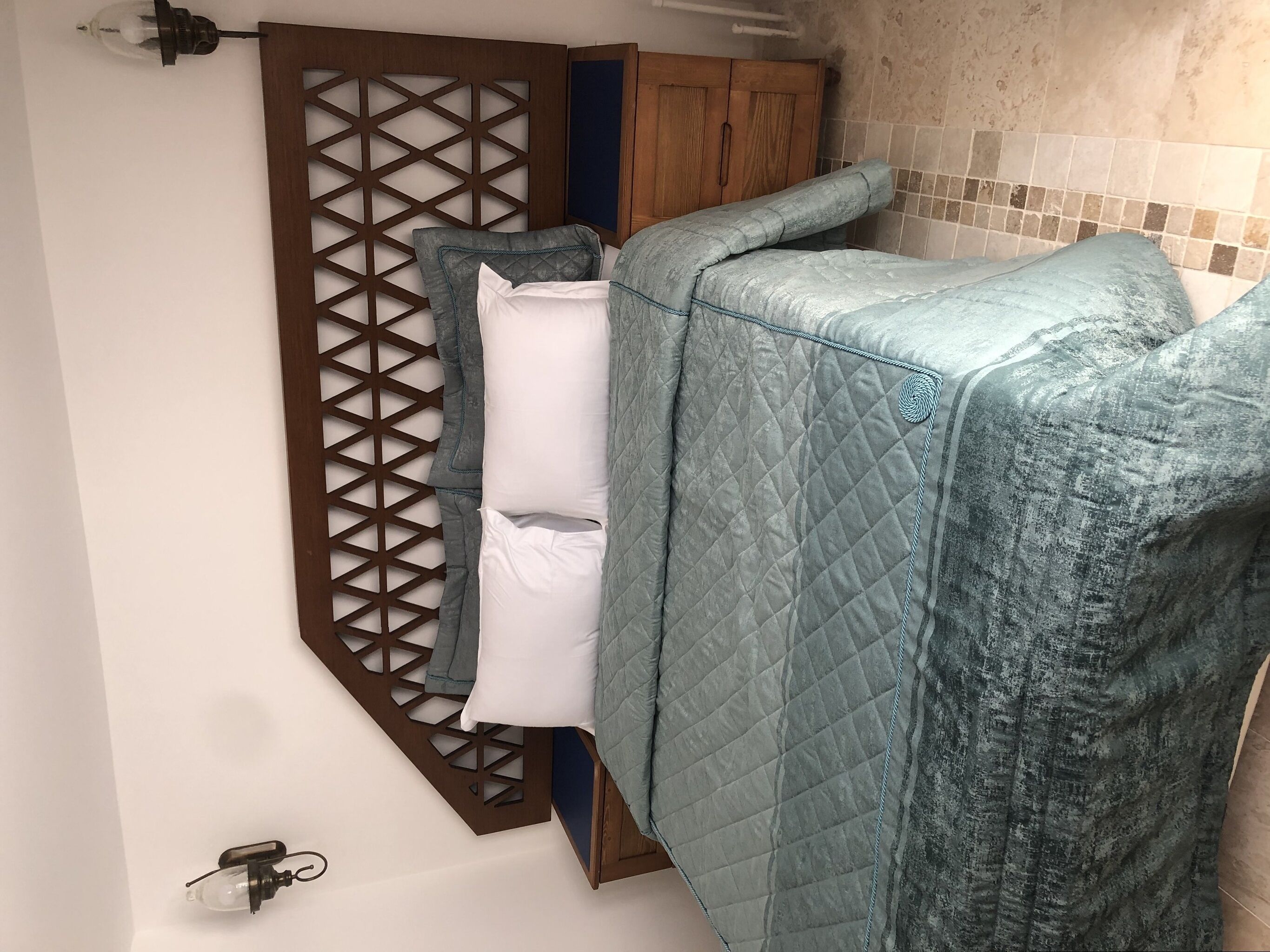 Un baño con separador de madera, una bañera y un perchero para toallas.