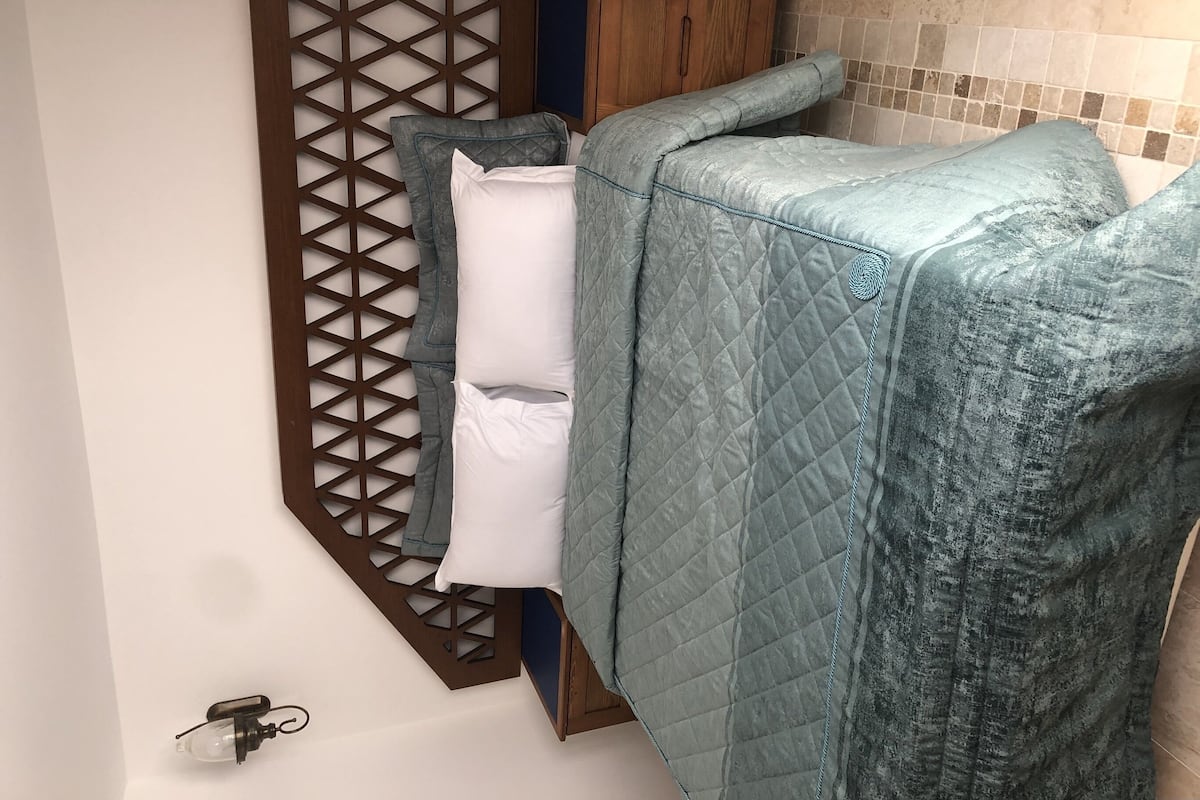 A bathroom with a wooden partition, a bathtub, and a towel rack.