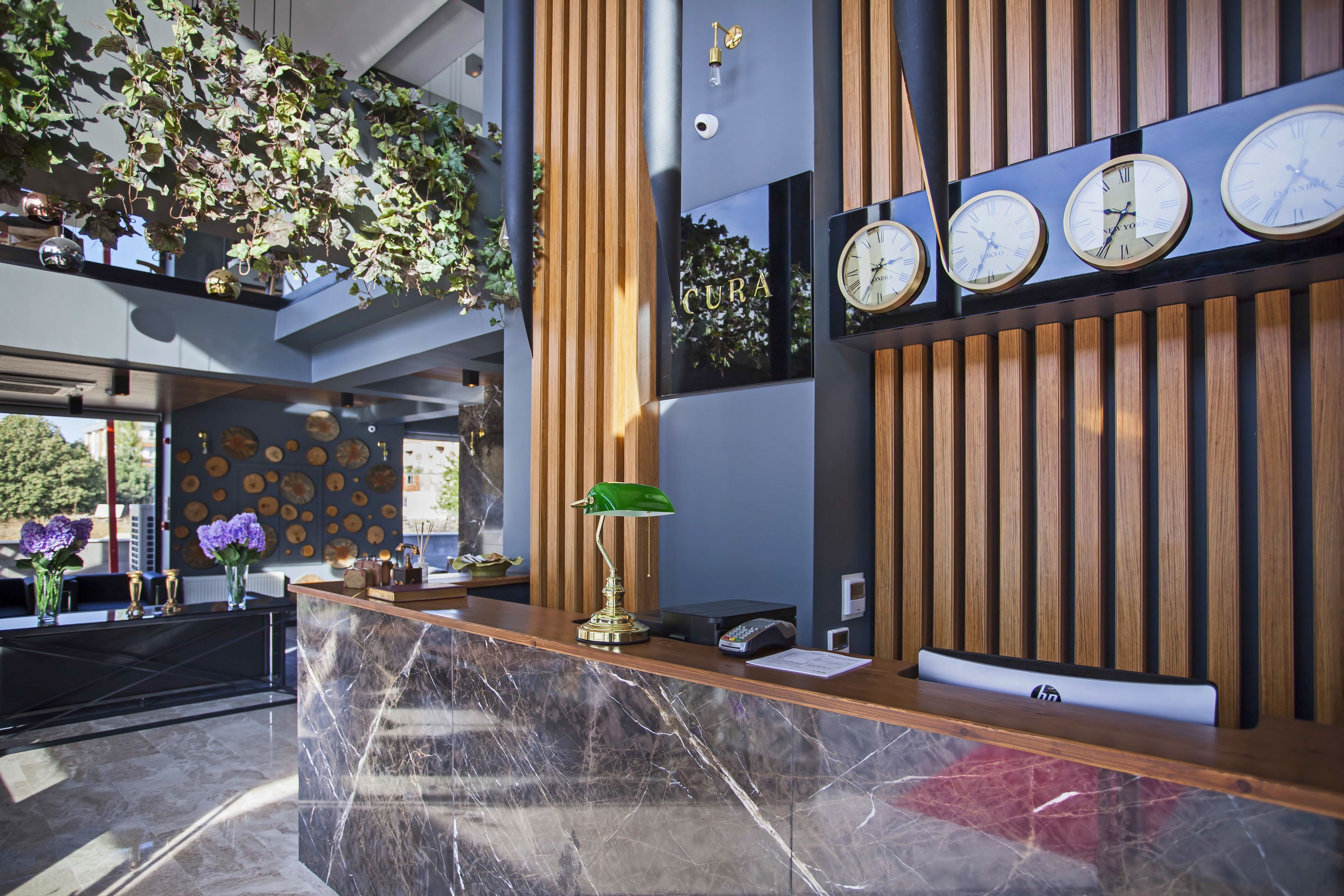A reception area with a marble counter, wooden paneling, and a wall-mounted clock.