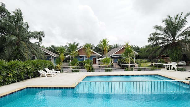 A swimming pool with lounge chairs and palm trees.