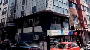 Un edificio de varios pisos con diseño moderno, que combina fachadas de vidrio y metal.