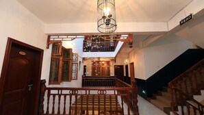 A staircase with wooden railings and a metal light fixture above.