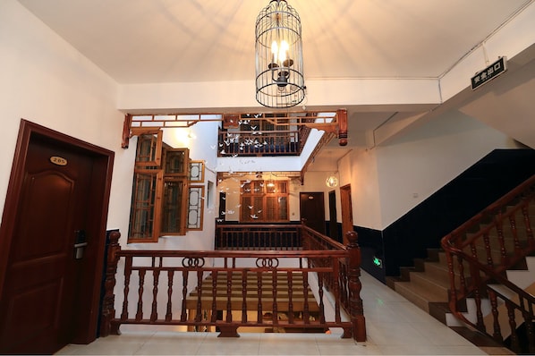 A staircase with wooden railings and a metal light fixture above.
