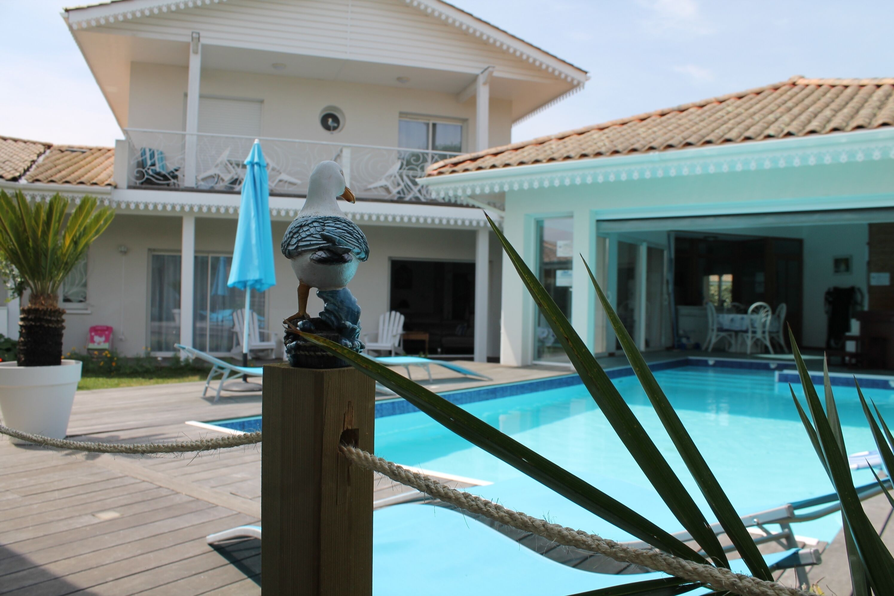A pool area with lounge chairs and a wooden deck.