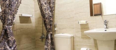 A bathroom with a toilet, sink, and shower.