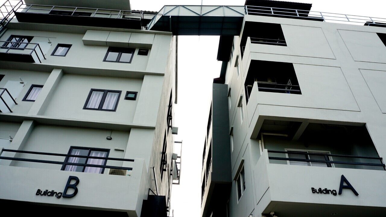 A multi-story building with balconies and a central walkway.