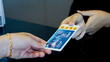 A hand holding a MasterCard with the number A3132.