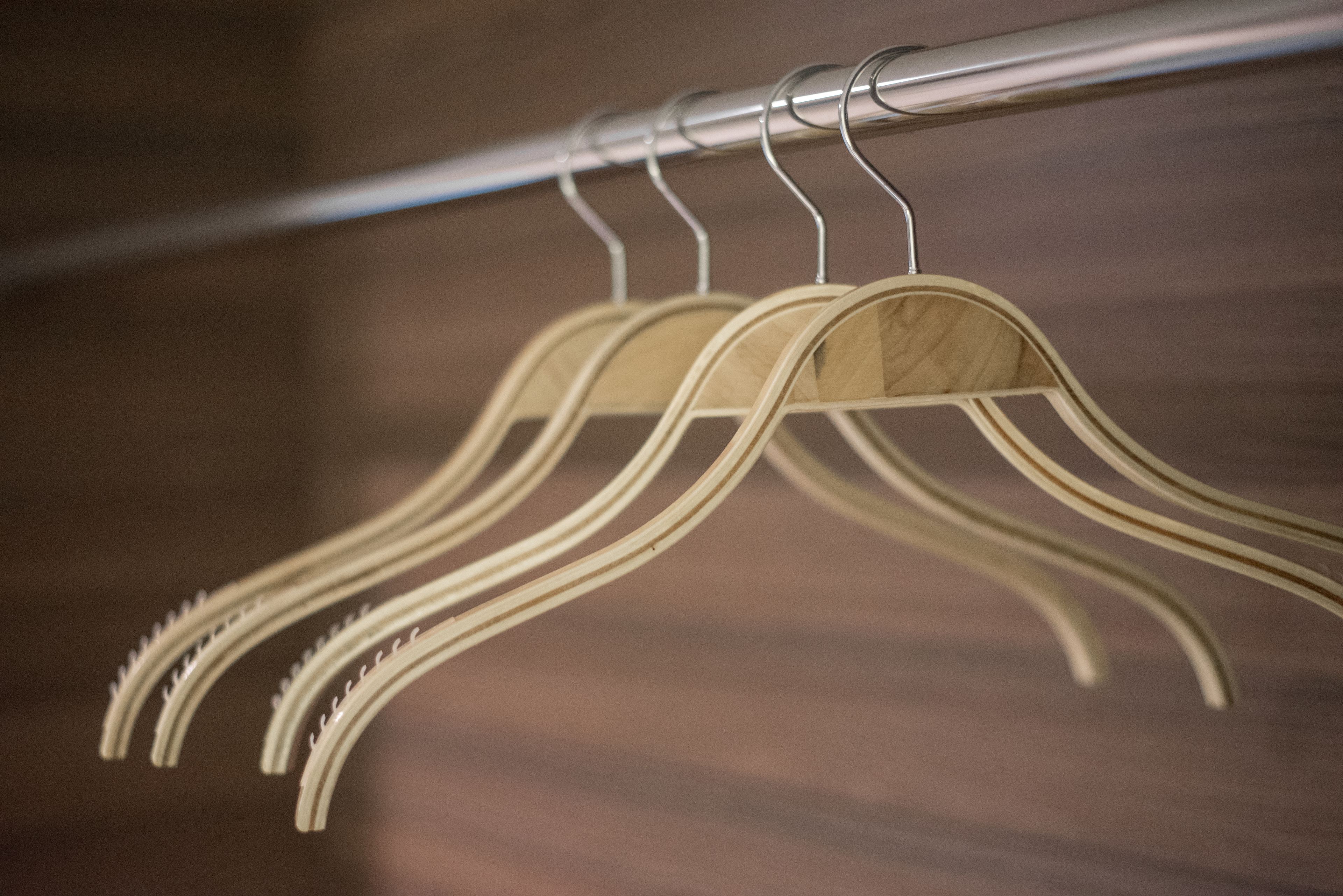 A metal rack with several wooden hangers.