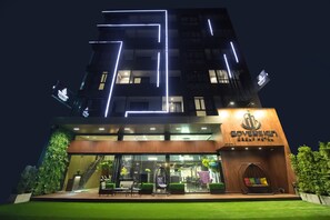 Ein Hotel mit modernem Design, erkennbar am auffälligen Logo und dem gut beleuchteten Eingang.