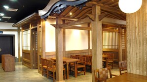 Interior de un restaurante japonés tradicional con mobiliario de madera y puertas correderas.