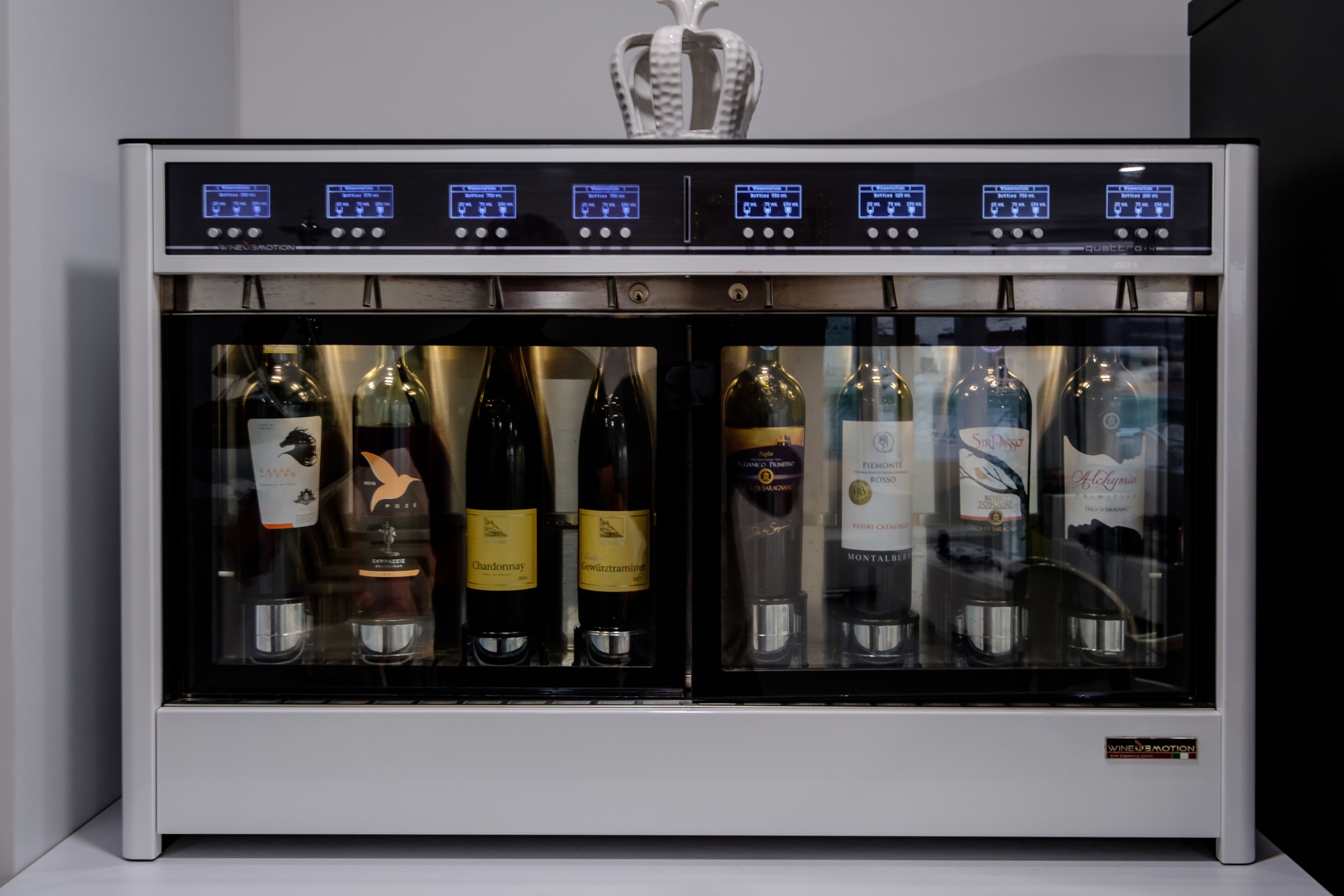 Ein Weinkühlschrank mit zahlreichen Weinflaschen, darunter Chardonnay und Pinot Noir, sowie einer digitalen Steuerung.