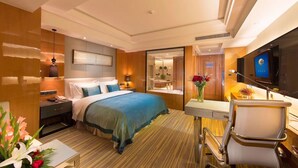 A hotel room with a bed, bedside table, lamp, and a TV. - R-Sun International Hotel Wuxi (Wuxi)