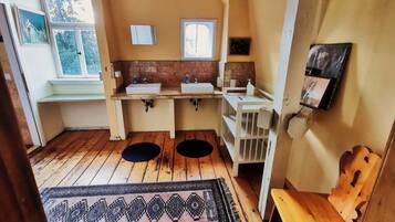 Una cocina compacta con dos fregaderos, piso de madera y alfombra estampada.
