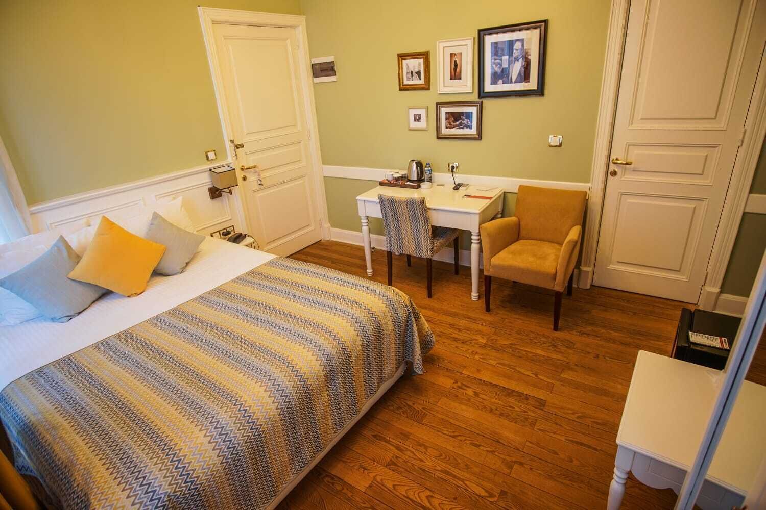 Ein Hotelzimmer mit Bett, Schreibtisch, Stuhl und einem kleinen Tisch.