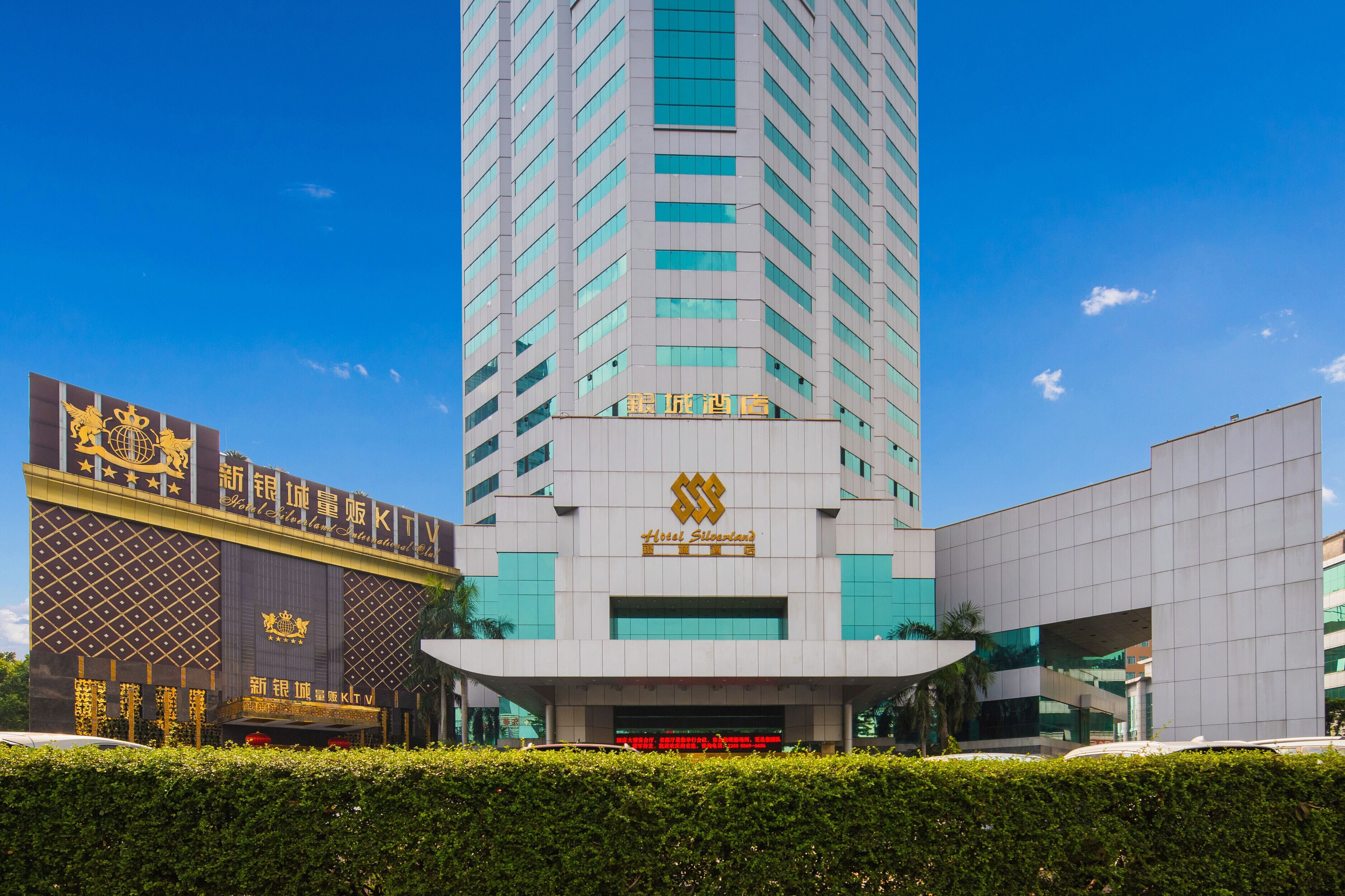 A modern hotel building with a prominent sign and a large entrance.