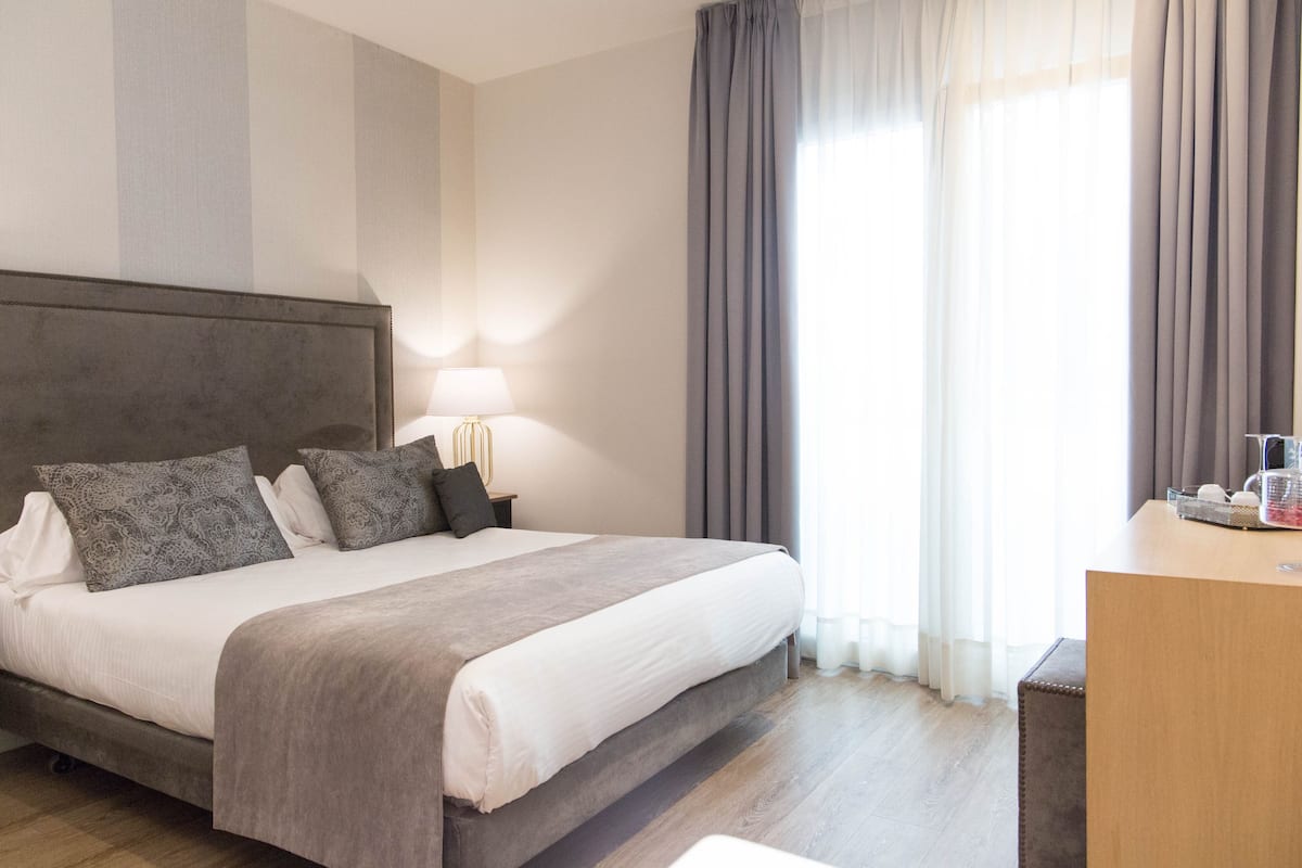 Une chambre d’hôtel avec un grand lit, un bureau et une lampe.