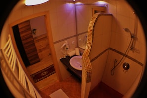 Une salle de bain avec un lavabo, un miroir et une douche.