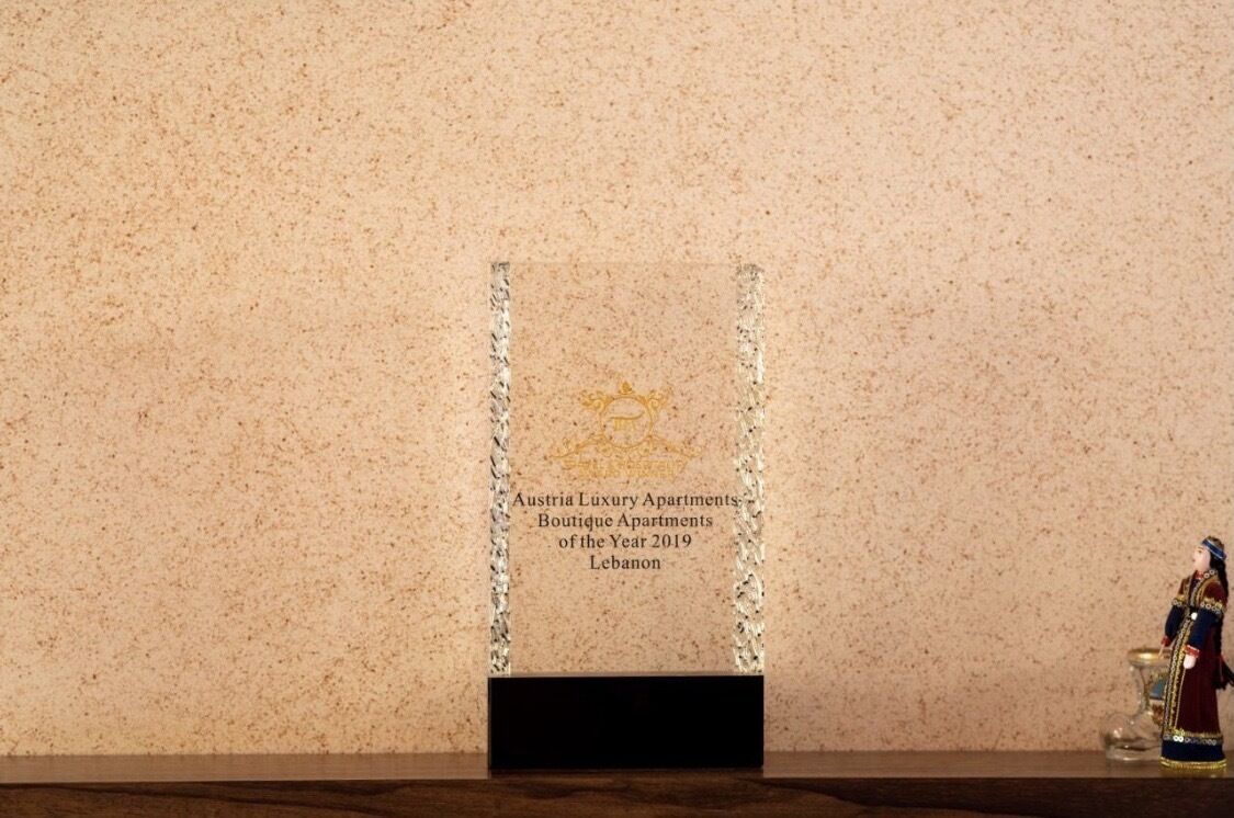 Una placa en una pared con texto sobre Austria Luxury Apartments, reconocido como Apartamentos Boutique del Año 2019 en Lebanon.