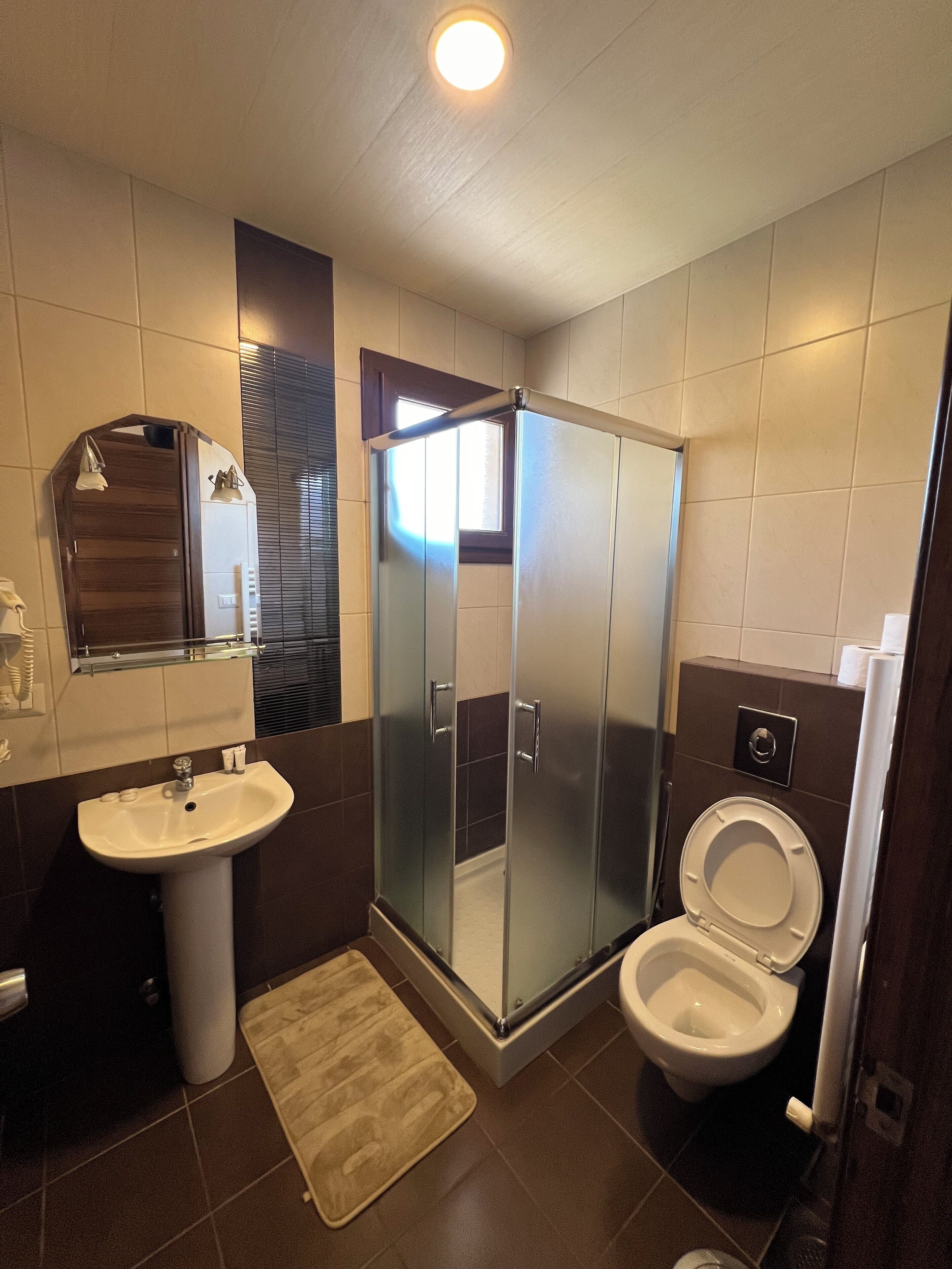 Une salle de bain moderne avec une douche à parois de verre, un lavabo et des toilettes.