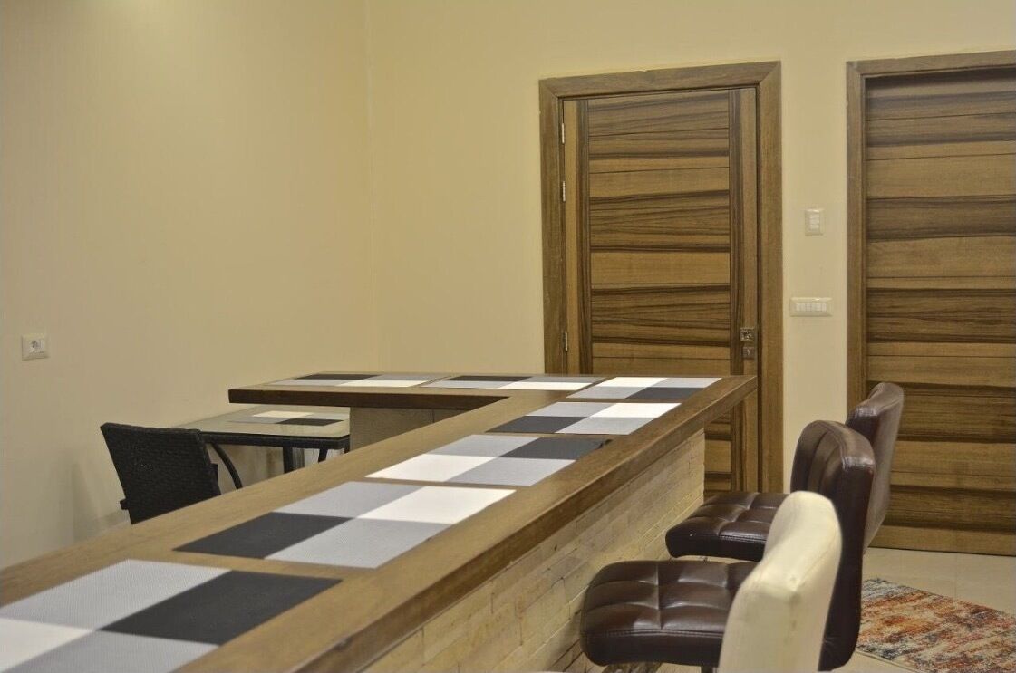 A conference room with a long table, two chairs, and wooden doors.