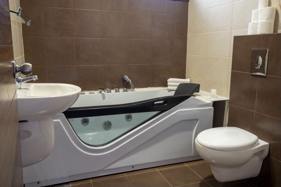 Un bagno moderno con una vasca da bagno bianca, un lavandino e un water.