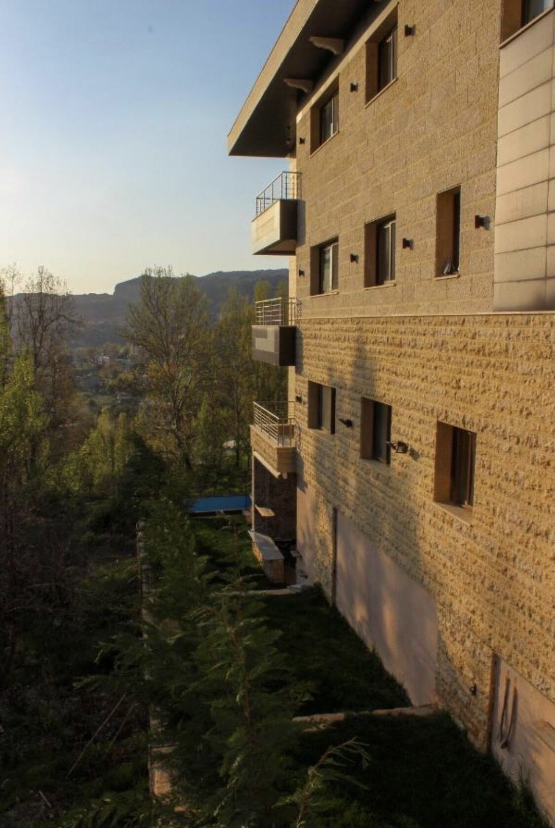 En bygning med flere etager, murstensfacade, mange vinduer og en balkon.