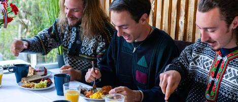 Three people dining at a table with breakfast items.