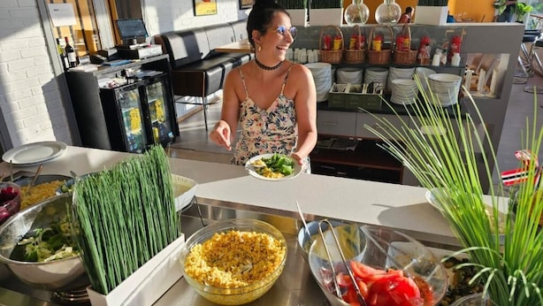 Un buffet proposant une variété de plats et une personne qui sert les clients.