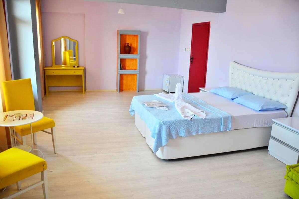 Un dormitorio con cama, mesita de noche y una silla.