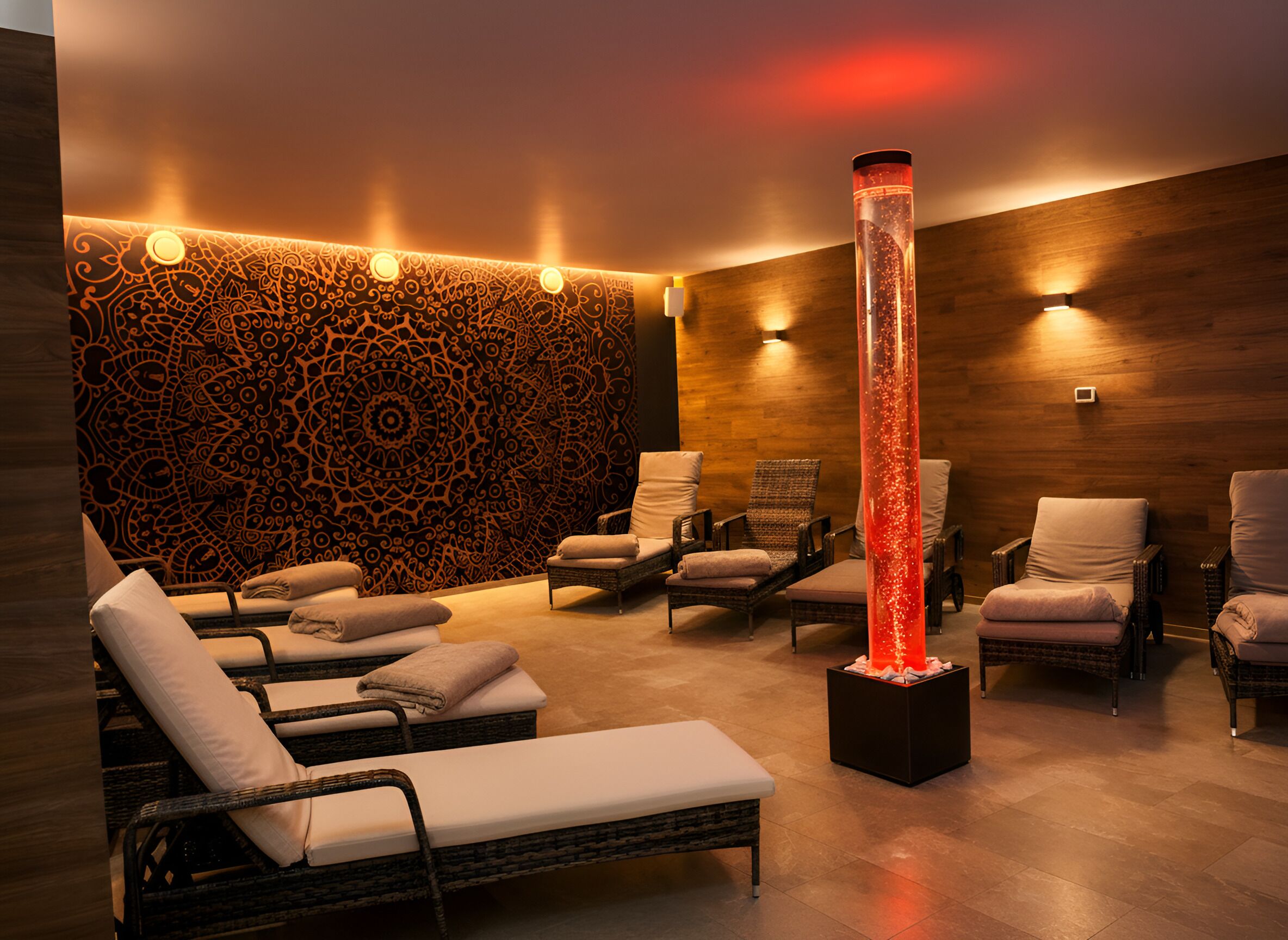 Un cuarto de spa con sillones reclinables, un muro decorativo y una fuente central.