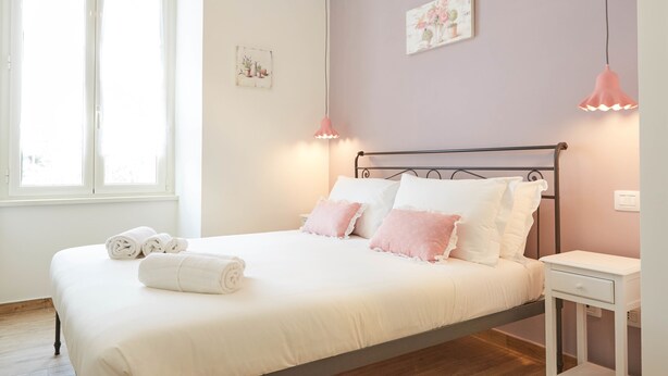 A bedroom with a bed, bedside table, and a window. - Colosseo Friendly Suite & Rooms (Rome)