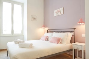 Une chambre à coucher avec un lit, une table de chevet et une fenêtre.