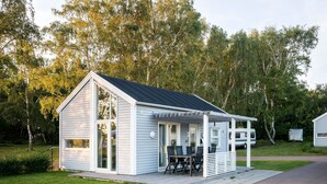 A small, single-story cabin with a porch and a dining area. - First Camp Råå Vallar Helsingborg (Råå)
