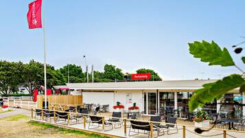 Un restaurant doté d’une terrasse, d’un drapeau et offrant une vue sur les environs.
