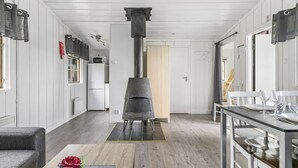 Una cocina moderna con estufa central, suelo de madera y paredes blancas.
