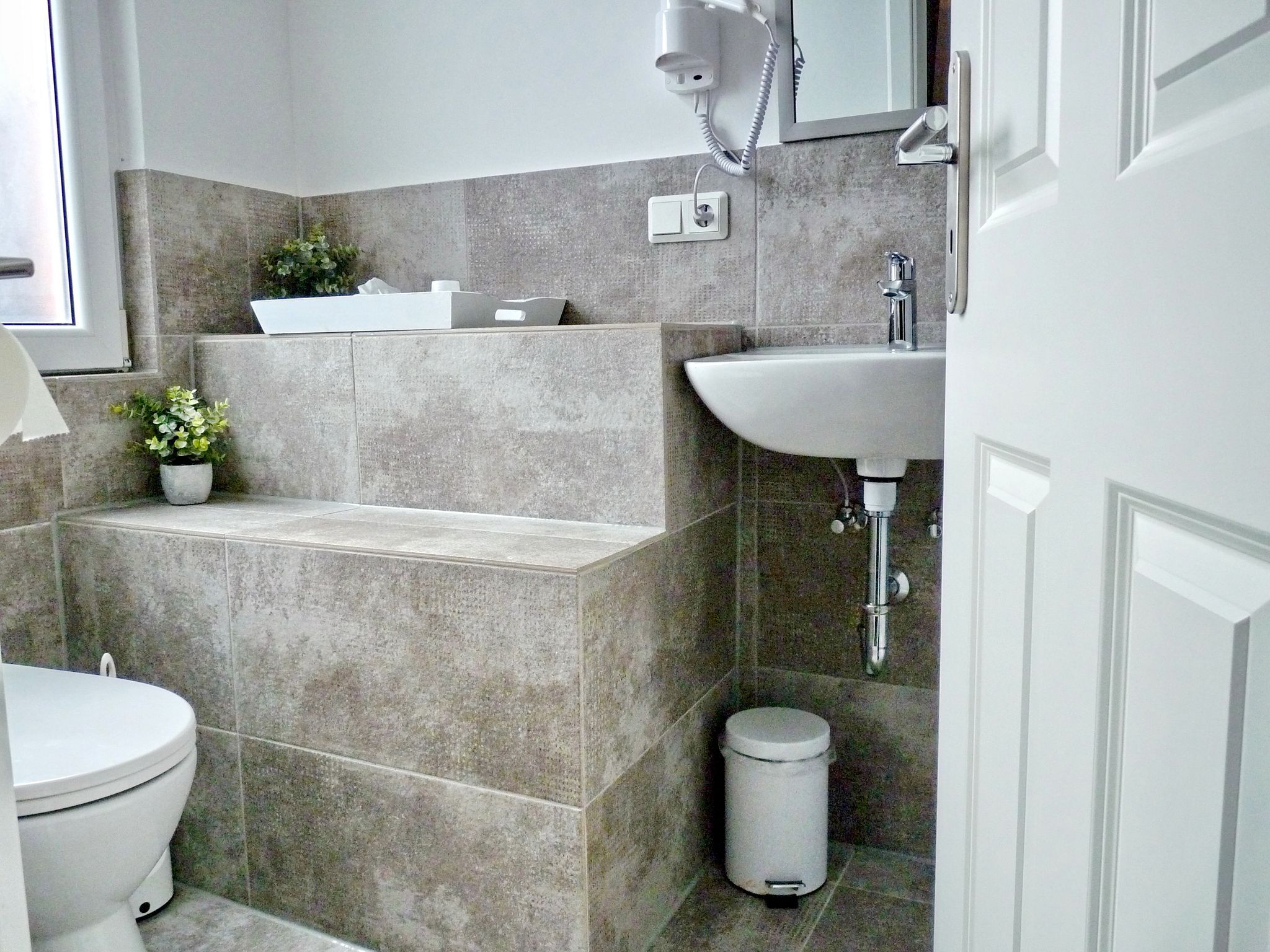 Un baño moderno con bañera, lavamanos e inodoro.